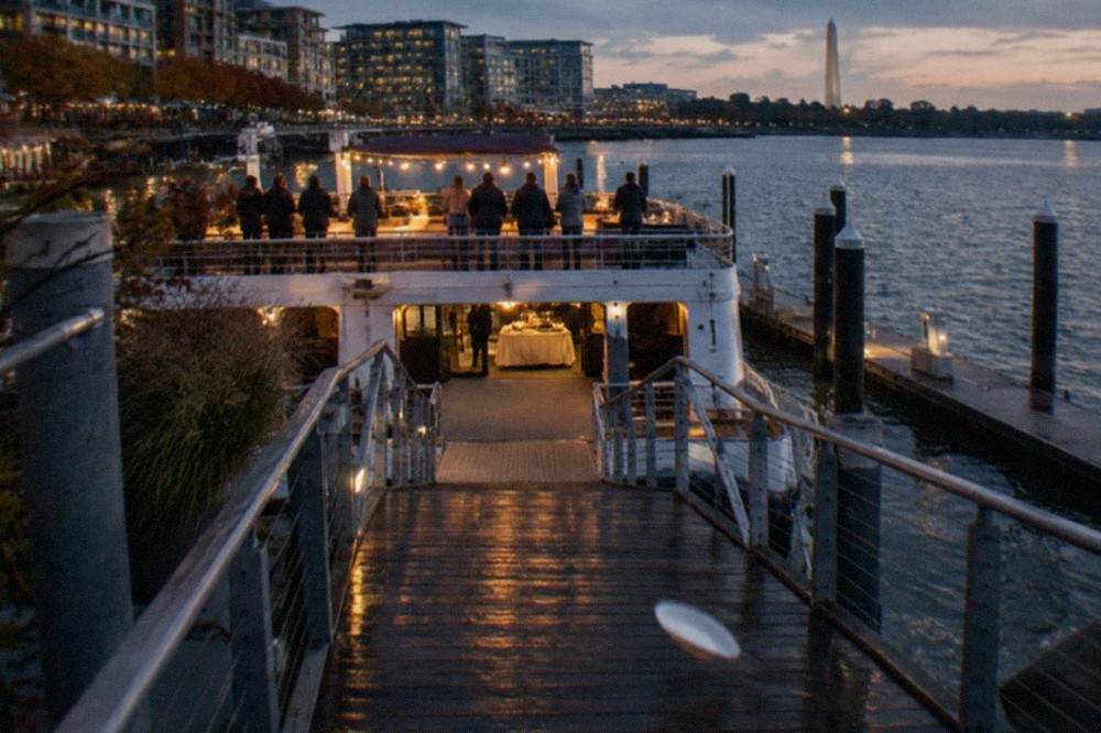A buffet dinner cruise boat lit up at its pier on the Washington waterfront in the evening