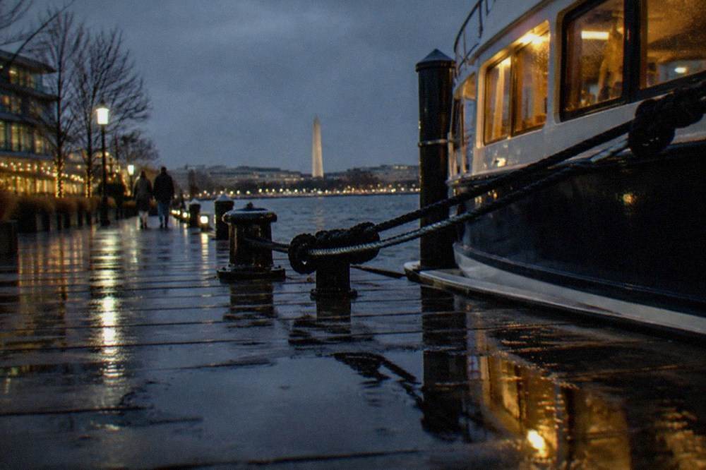 A cruise pier at the Washington waterfront with the gangway and moored boat visible at dusk