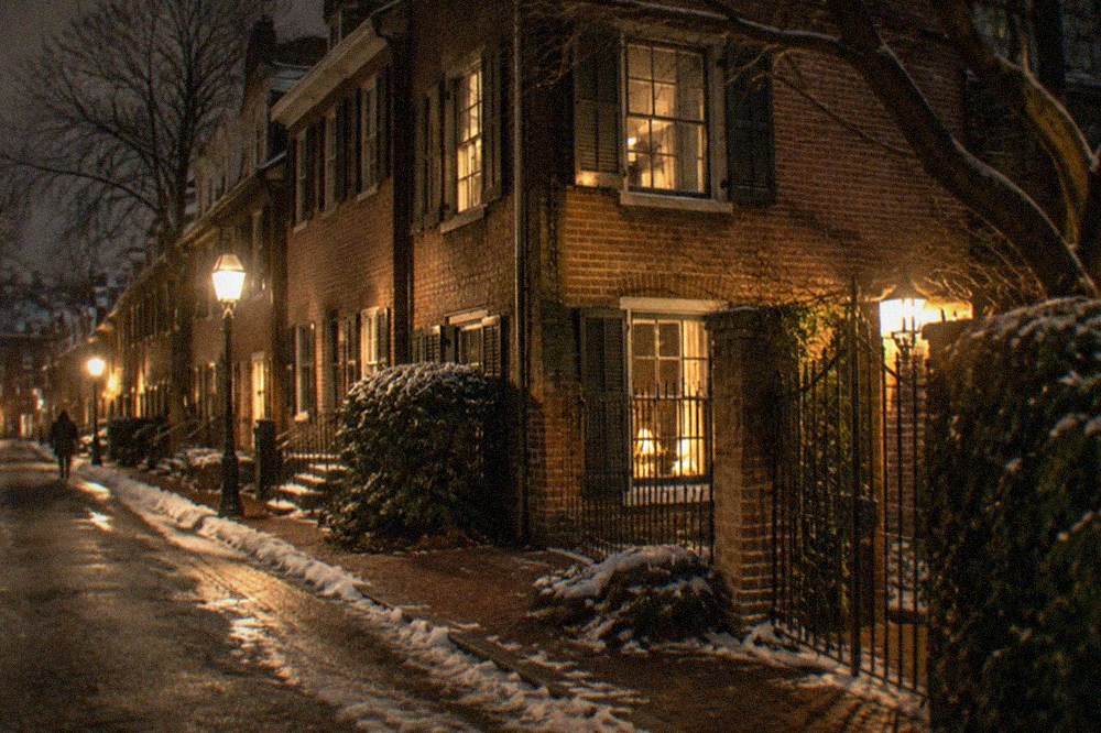 A narrow lamplit brick street in Georgetown at night with old row houses