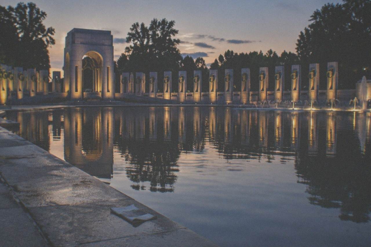Illuminated memorials along the National Mall reflected in the water at night