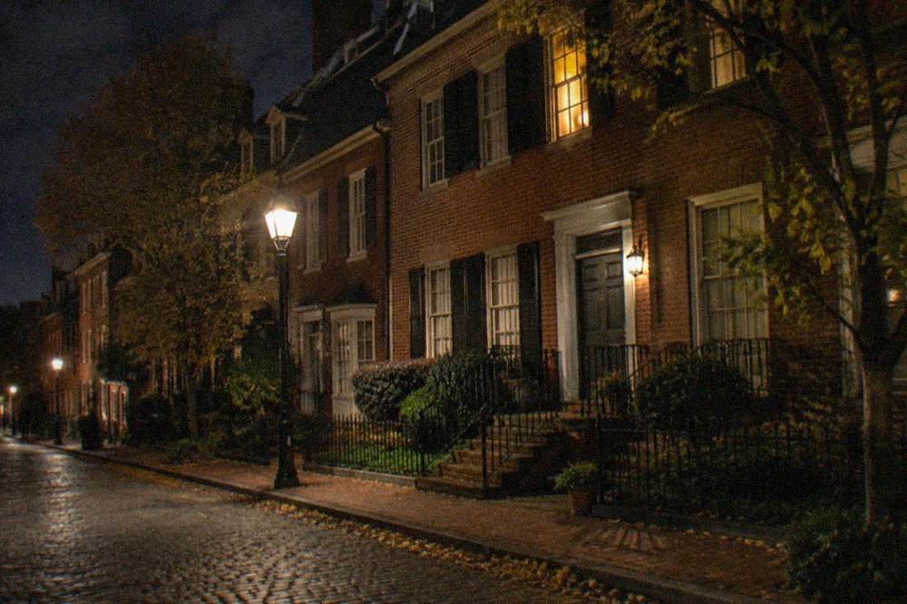 Georgetown's cobblestone streets lined with historic row houses under streetlights at night