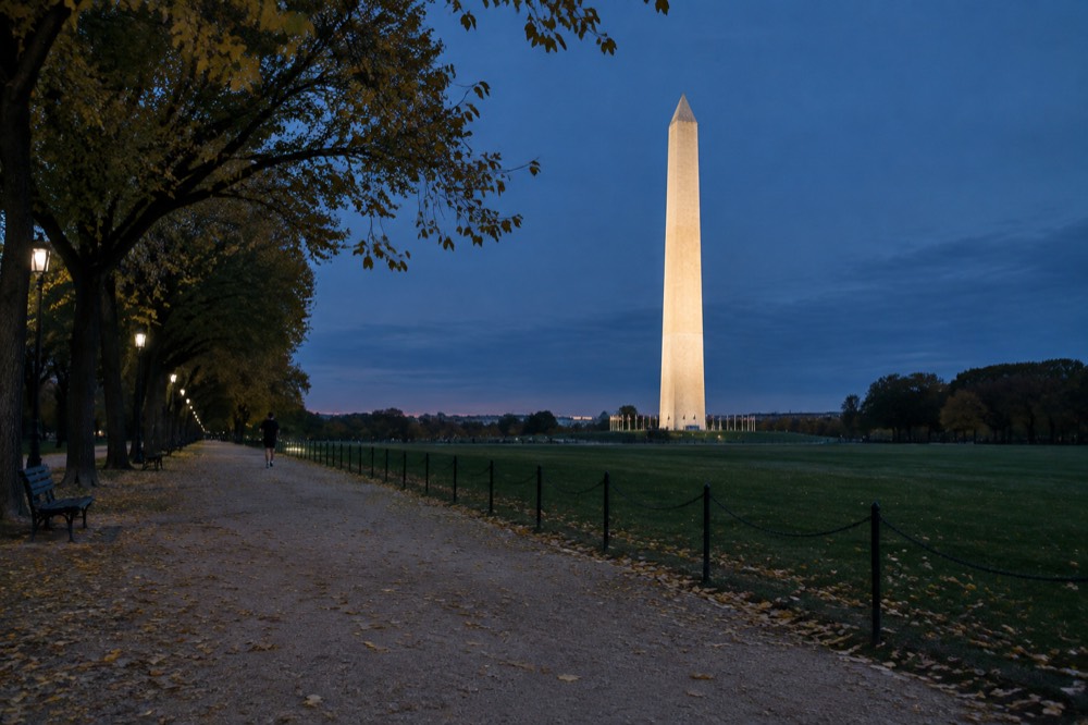 Washington Monument obelisk glowing against a deep blue evening sky