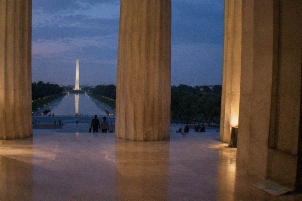 Lit columns of the Lincoln Memorial glowing against a dark sky at night