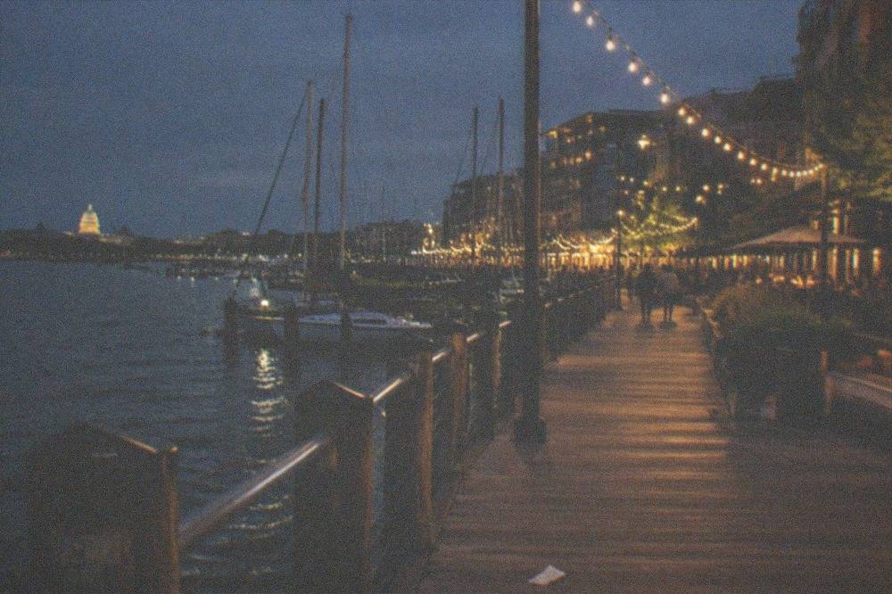 Georgetown riverside promenade with lit trees and reflections on the Potomac at night