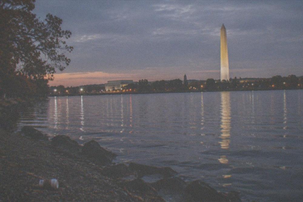 City skyline and monument lights seen from across the river at night