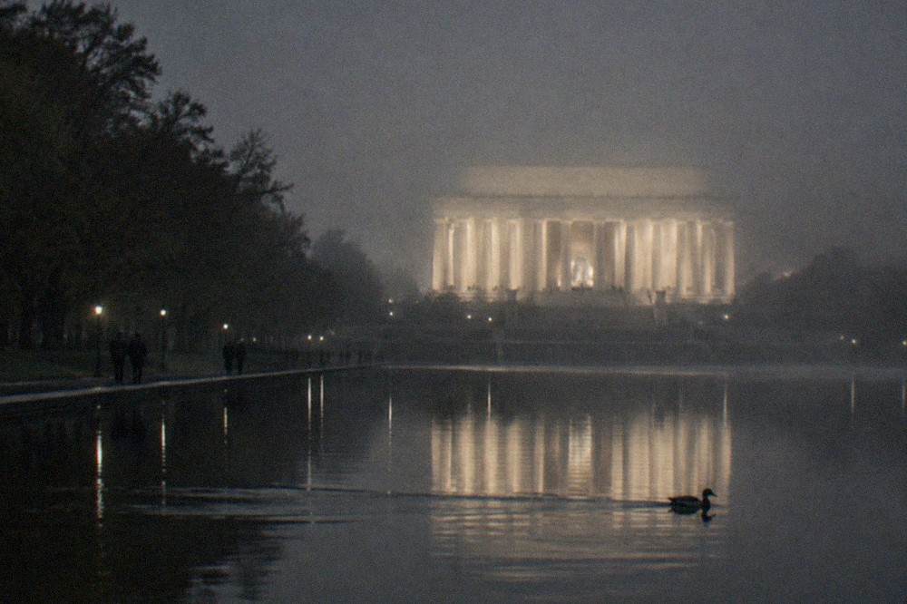 The Lincoln Memorial seen from across the Reflecting Pool at night, illuminated columns reflected in still water