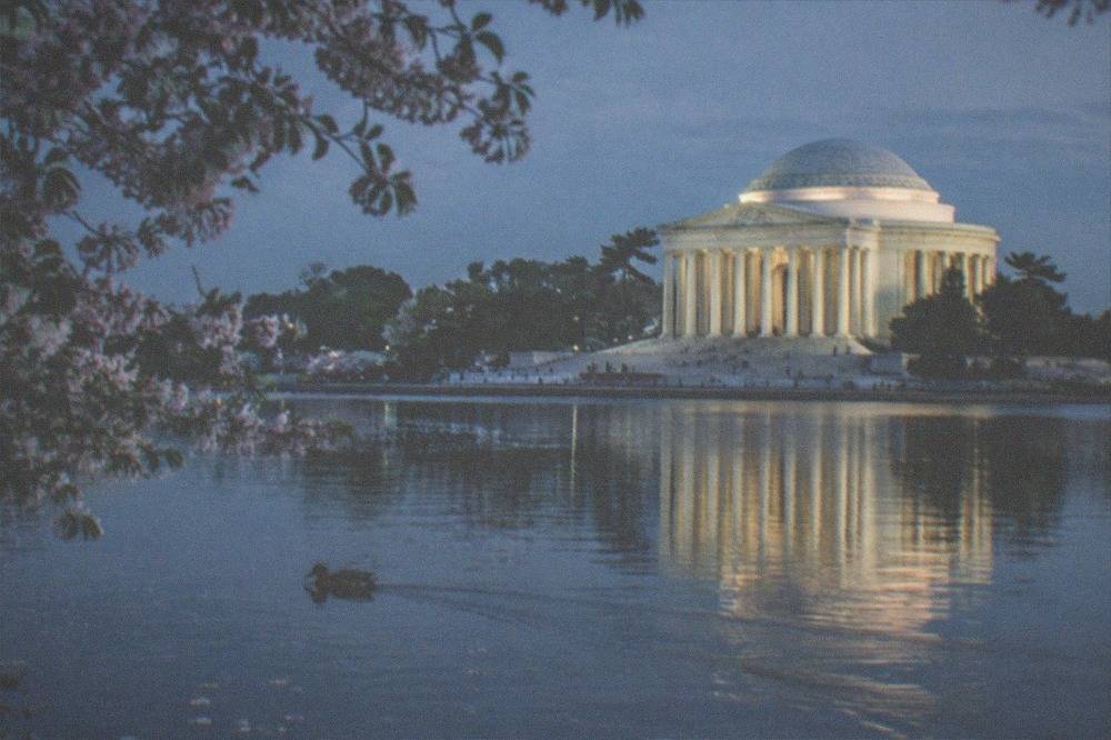 The Jefferson Memorial glowing above the Tidal Basin with its lit dome reflected in still water