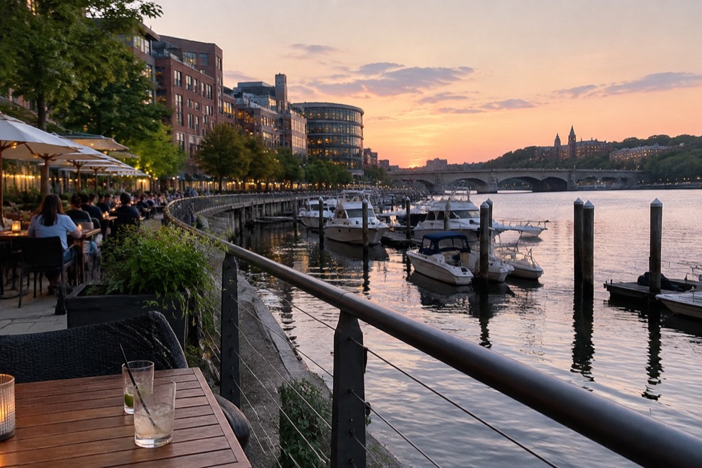 The Georgetown Waterfront harbor at dusk with restaurant terraces and boats moored along the pier