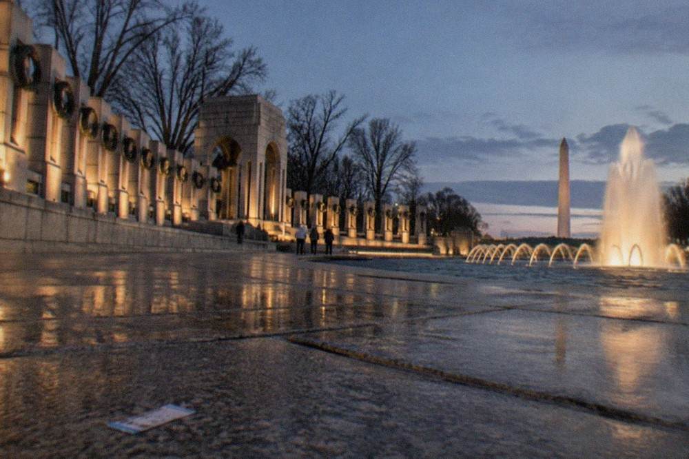 The Washington Monument illuminated against a dark sky above the National Mall