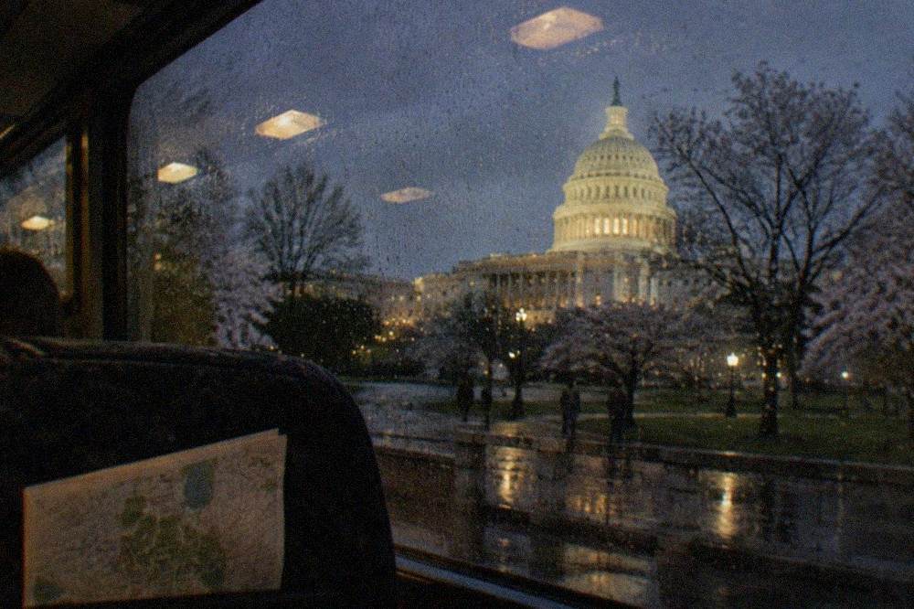 The illuminated Capitol dome seen from a night tour vehicle window