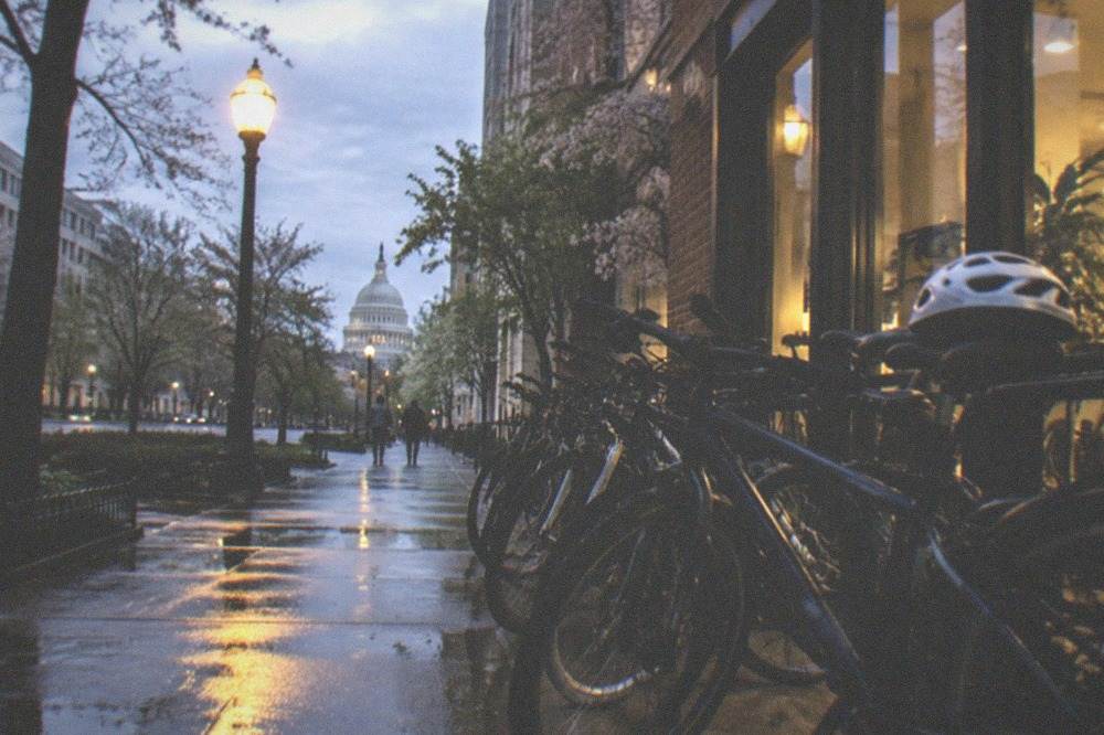 A row of bicycles parked under glowing streetlights before a night ride